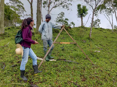 Maria Tereza, coordenadora de campo orientando a equipe sobre o uso do pé de galinha, ferramenta utilizada para plantar em nível